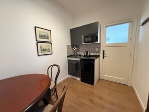 Suite Deluxe, patio, vistas a la ciudad | Cocina privada | Frigorífico pequeño, microondas, placa de cocina y utensilios de cocina