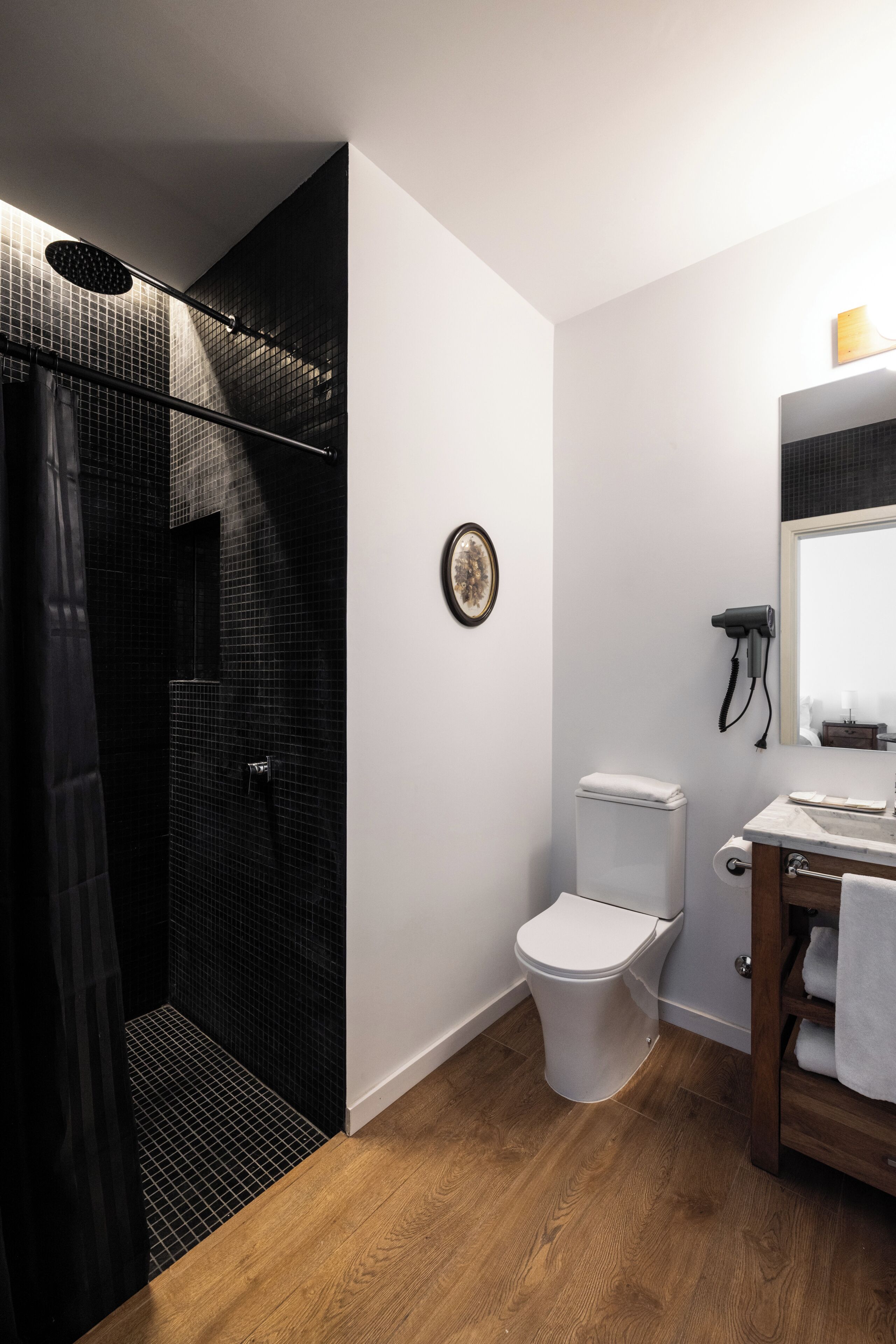 A modern bathroom with a shower, toilet, and vanity.