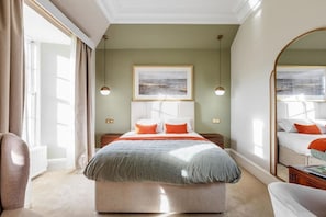 A bedroom with a large bed, a mirror, a framed picture on the wall, and a window with curtains. - Cally Palace (Castle Douglas)