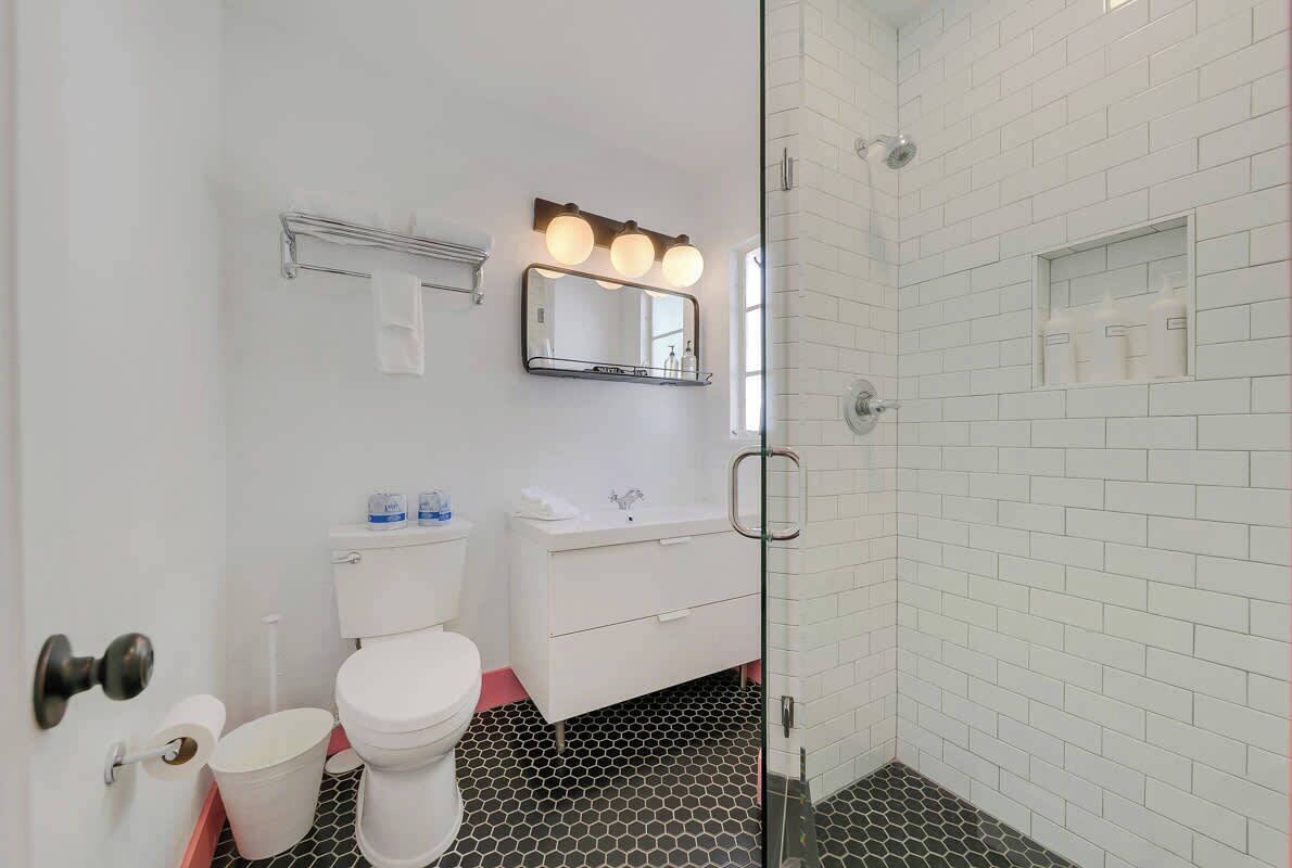 A bathroom with a toilet, sink, and shower area.