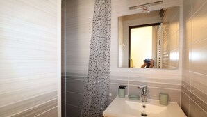 A bathroom with a sink, mirror, and shower curtain. - 2-room apartment for 4 people, 5 minutes from the beach (LE GRAU DU ROI)