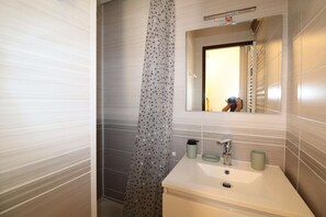 Ein Badezimmer mit Waschbecken, Spiegel und Duschvorhang.