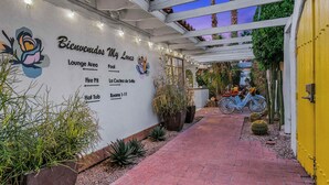 A hotel entrance with a sign indicating a lounge area, fire pit, and rooms 1-11. - Spirit of Sofia 12bd (Palm Springs)