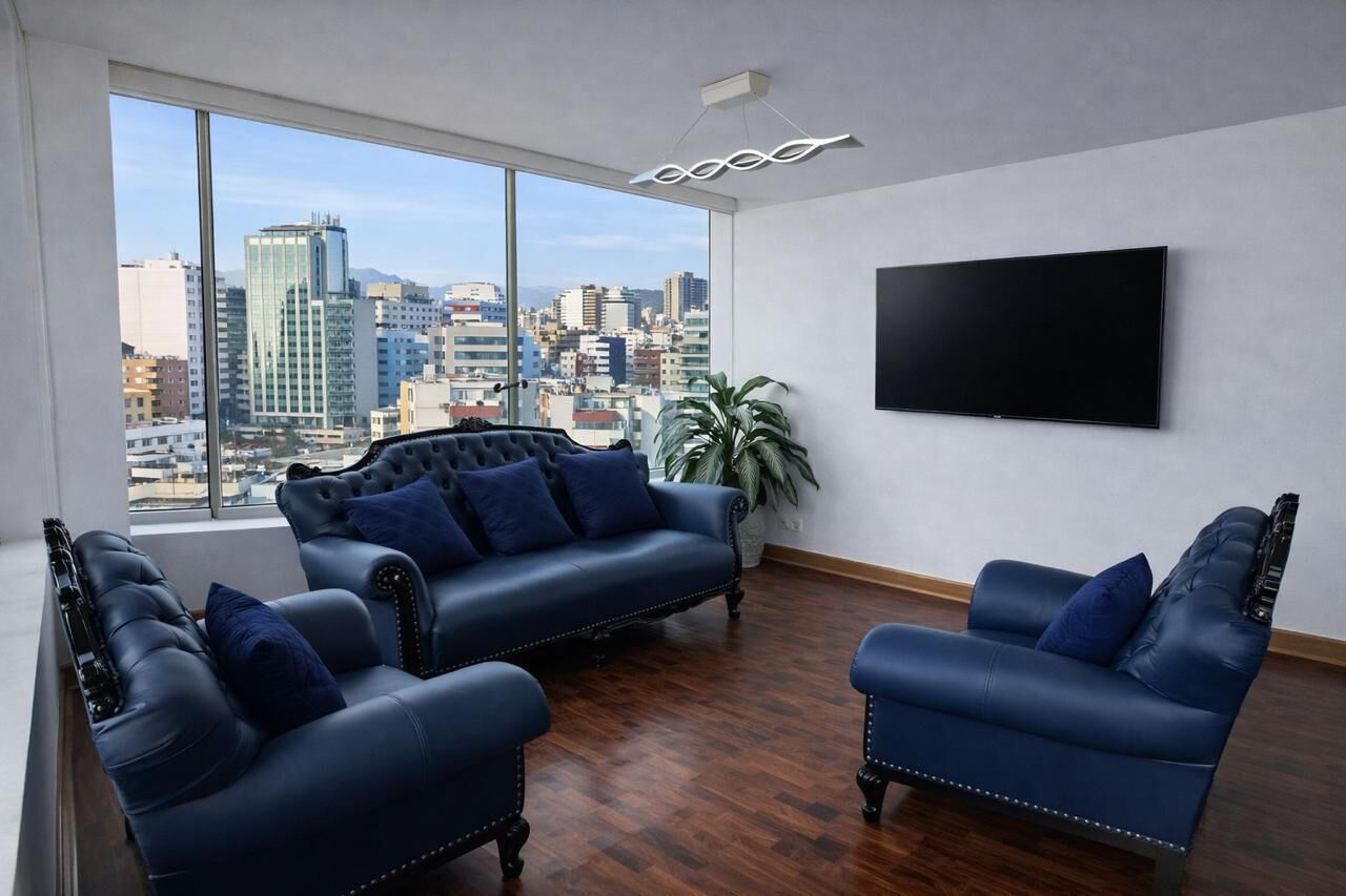Uma sala de estar moderna com vista para a cidade, uma televisão de tela plana e sofás de couro.