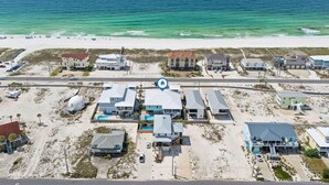 Vista aérea de una zona residencial costera con casas, una playa y el océano.