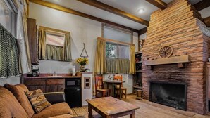 Ein gemütliches Wohnzimmer mit Kamin, Essbereich und einer Küche mit Einbauofen.