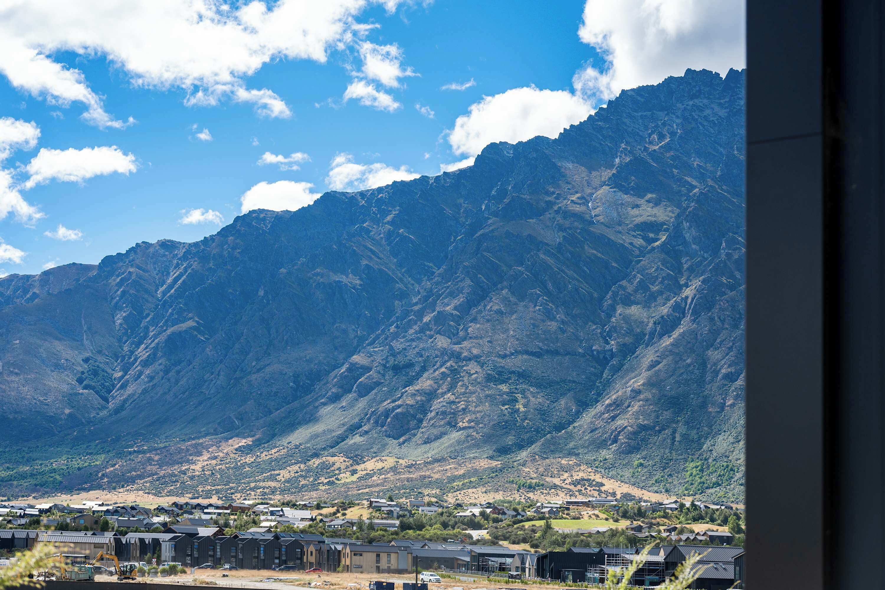 A mountainous landscape with a residential area in the foreground.