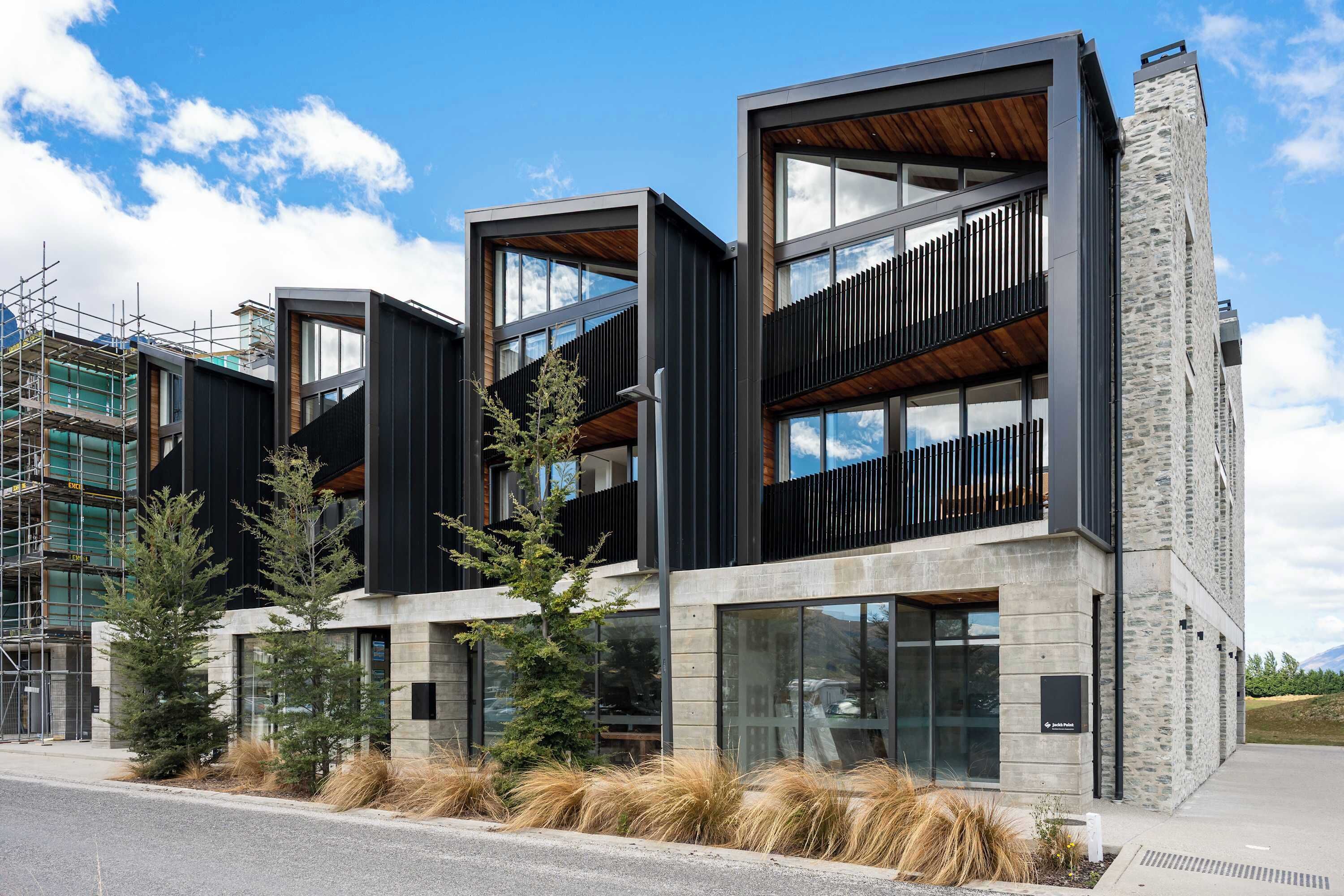 Un bâtiment moderne à plusieurs étages, doté de grandes fenêtres et d’une façade en pierre.