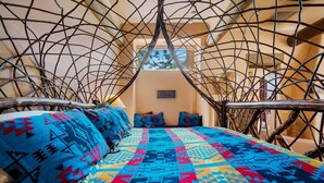 Ein Zimmer mit einem Bett, einem Fenster und einer Wand mit dekorativem Muster.