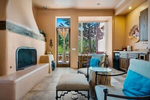 A room with a fireplace, a dining area, and a kitchen. - Purple Lizard- Sedona Villas (Sedona)