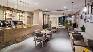 A modern hotel lobby with a bar area, seating arrangements, and artwork on the walls. - Aber Al Takhassusi Hotel (Riyadh)