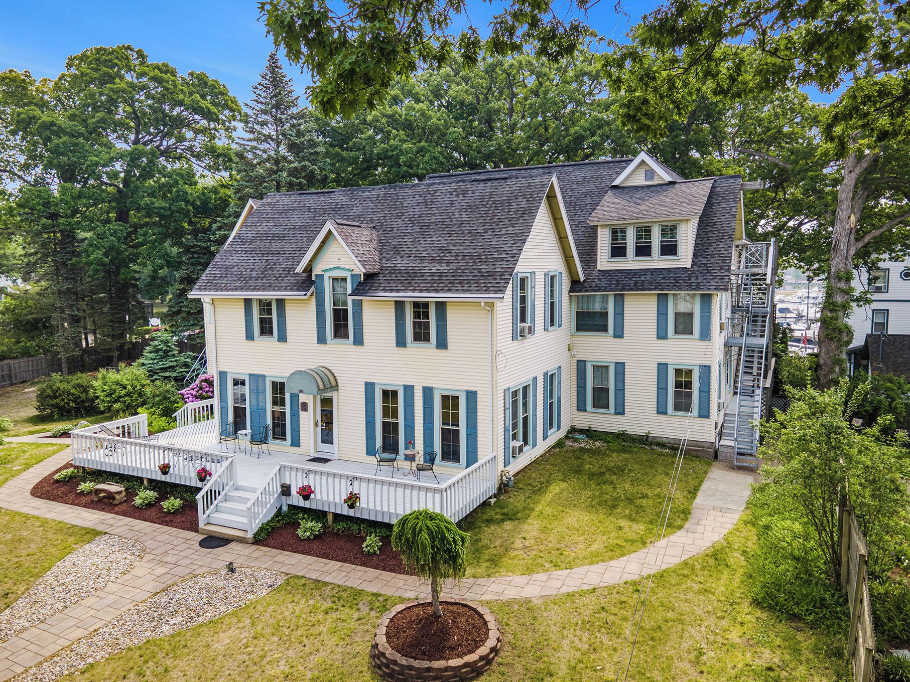A two-story house with a porch, a front yard, and a driveway.
