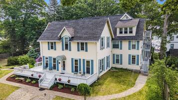 A two-story house with a porch, a front yard, and a driveway.
