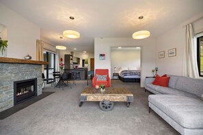 TV, fireplace, books - Lake Hayes retreat offers breathtaking mountain and lake views with modern luxury amenities. (Lake Hayes)