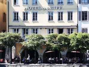 Ein Hotel namens 'HOTEL SCHIFF' im klassischen europäischen Architekturstil, mit einer Reihe von Fenstern und einem zentralen Eingang.