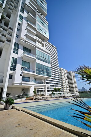 A modern high-rise hotel with a swimming pool, multiple balconies, and a clear blue sky. - Luxury apartment in cartagena| design +comfort (Cartagena de Indias)