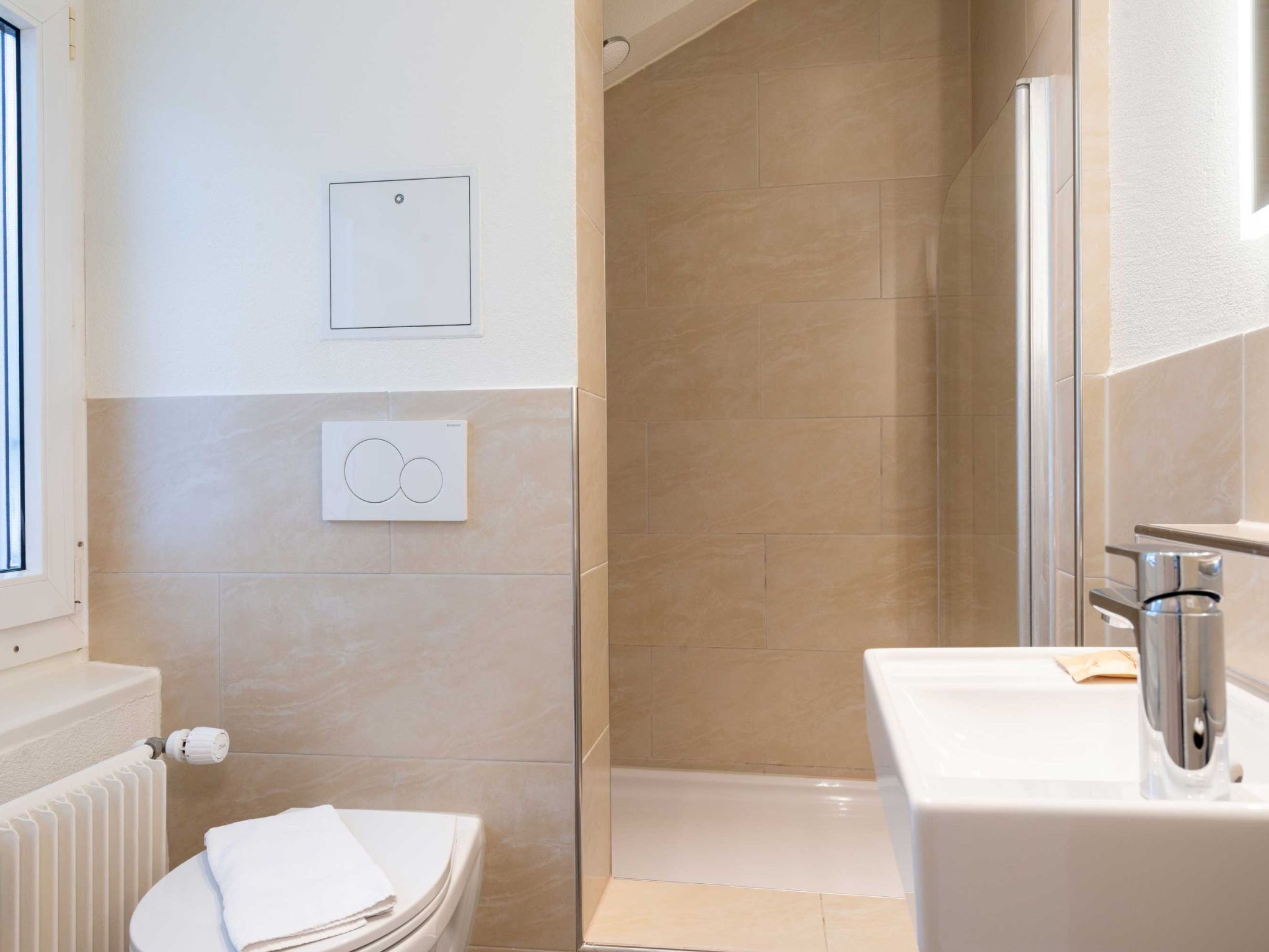 Un baño moderno con ducha, inodoro y lavabo.