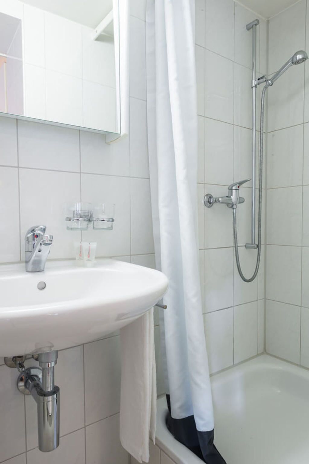 Ein Badezimmer mit einem weißen Waschbecken, einer Dusche und einer Badewanne.