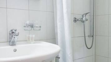 Ein Badezimmer mit einem weißen Waschbecken, einer Dusche und einer Badewanne.