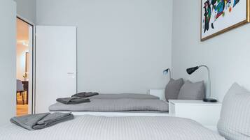 Una camera da letto moderna con un letto, comodini, una lampada e un quadro appeso al muro.