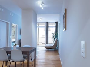 Una sala de estar moderna con comedor, un ventanal y vistas al exterior.