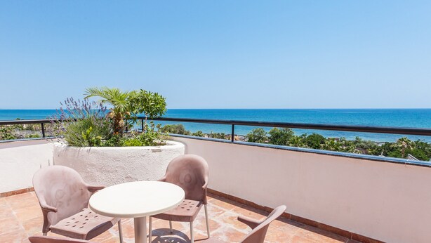 A terrace with a table and chairs, overlooking a beach and the sea. - Magic Games (Oropesa del Mar)