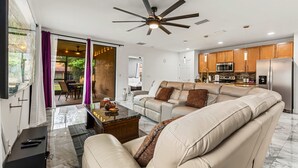 A modern living room with a sofa, coffee table, and a ceiling fan. - Family-Friendly 4BR Villa Near Disney - Kissimmee (Kissimmee)
