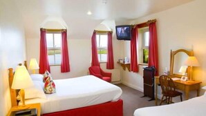 A hotel room with two beds, a TV, a desk, and a chair.