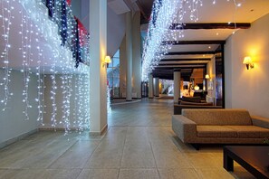 A hotel lobby with a sofa, a coffee table, and decorative string lights. - Monte Baia Uludag Hotel (Bursa)
