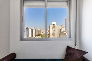 Ein Zimmer mit Fenster und Blick auf die Stadt.