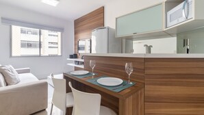 Una cocina moderna con comedor, refrigerador y microondas.