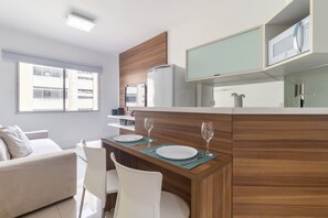 Eine moderne Küche mit Essbereich, Kühlschrank und Mikrowelle.