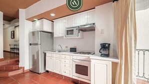 A kitchen with white cabinets, a refrigerator, a microwave, and a coffee maker. - One Beach Street 406 - Amazing 1 BR Condo (Puerto Vallarta)