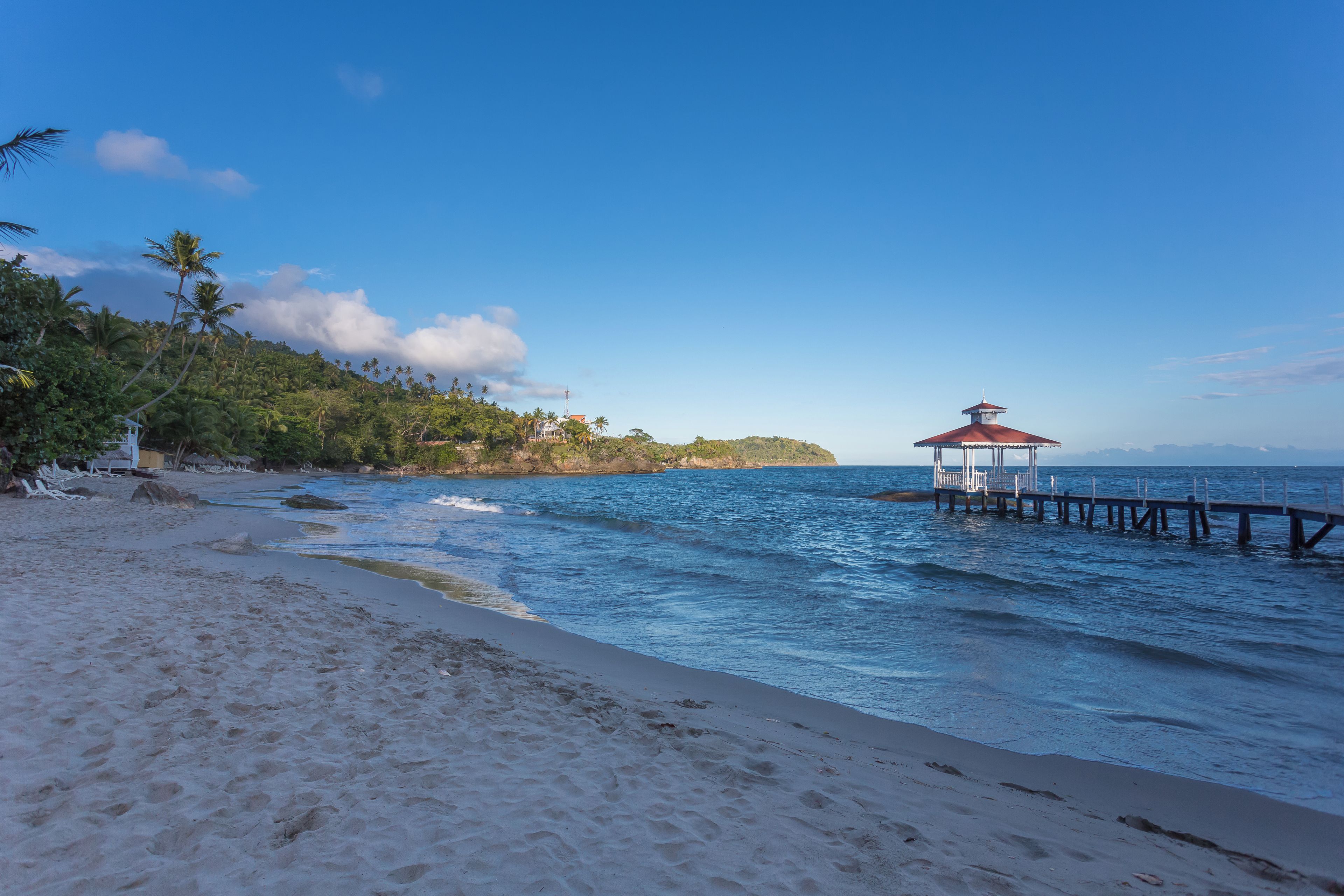 A beach with a pier and a gazebo.