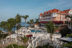 Un resort con piscina, varios balcones y vista al océano.