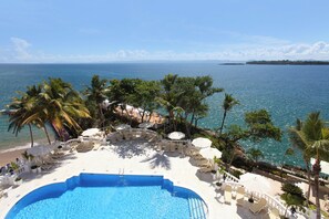 A poolside area with lounge chairs and umbrellas, overlooking a beach and ocean. - Bahia Principe Escape Samaná Hyatt Incl Co Adult O (Samaná)