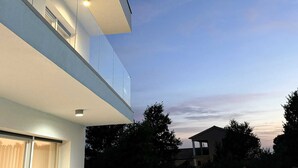 Ein modernes Gebäude mit flachem Dach, großen Fenstern und einem Balkon.