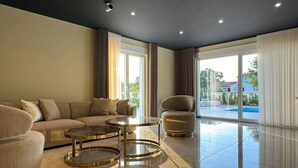 Ein modernes Wohnzimmer mit einer Couch, zwei runden Tischen und einem Sessel.
