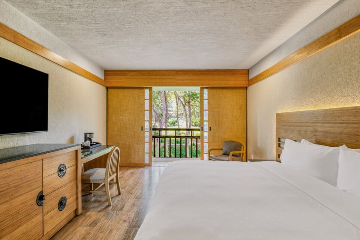 Une chambre à coucher avec un lit, un bureau, une chaise et un téléviseur.