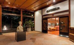 Un intérieur japonais traditionnel avec un plafond en bois, une statue et un motif de paon sur la porte.