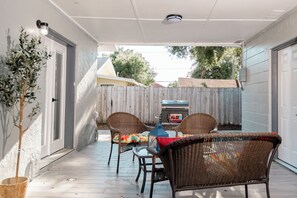 A covered patio with wicker furniture, a grill, and a potted plant. - Tampa Retreat, 4 min to Stadium, Airport, sleeps (Tampa)