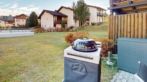 Ein Wohngebiet mit Häusern, einem Grill und einem Holzzaun.