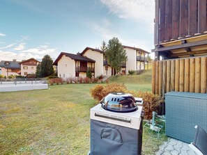 A residential area with houses, a barbecue grill, and a wooden fence. - 1905 Tgampi Sot Lantsch/Lenz by Interhome (Lantsch)