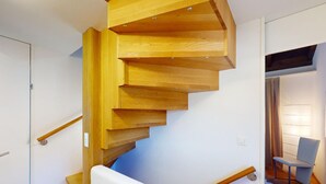 Eine Holzspirale mit weißer Handlauf und einer blauen Akzentwand.