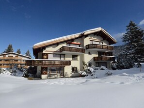 A multi-story chalet with balconies, surrounded by snow-covered trees. - 1615 Bot La Pala by Interhome (Lenzerheide)