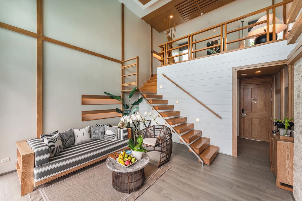 A modern living room with a sofa, coffee table, and staircase.