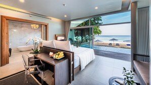 A modern hotel room with a large bed, a desk with a fruit bowl, a view of the beach, and a glass-enclosed balcony. - Aleenta Phuket - Phang Nga Resort and Spa (Takua Thung)
