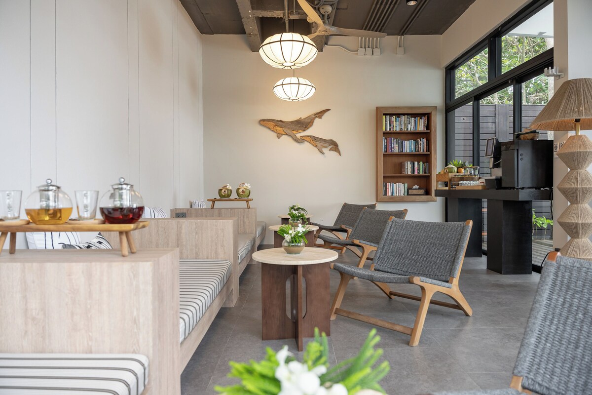 Uma sala de estar moderna com sofá, cadeiras, mesa de centro, estante e lareira.