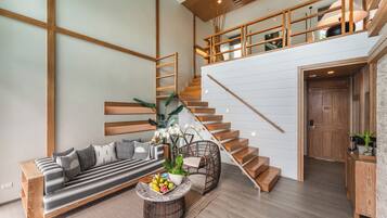 A modern living room with a sofa, coffee table, and staircase.