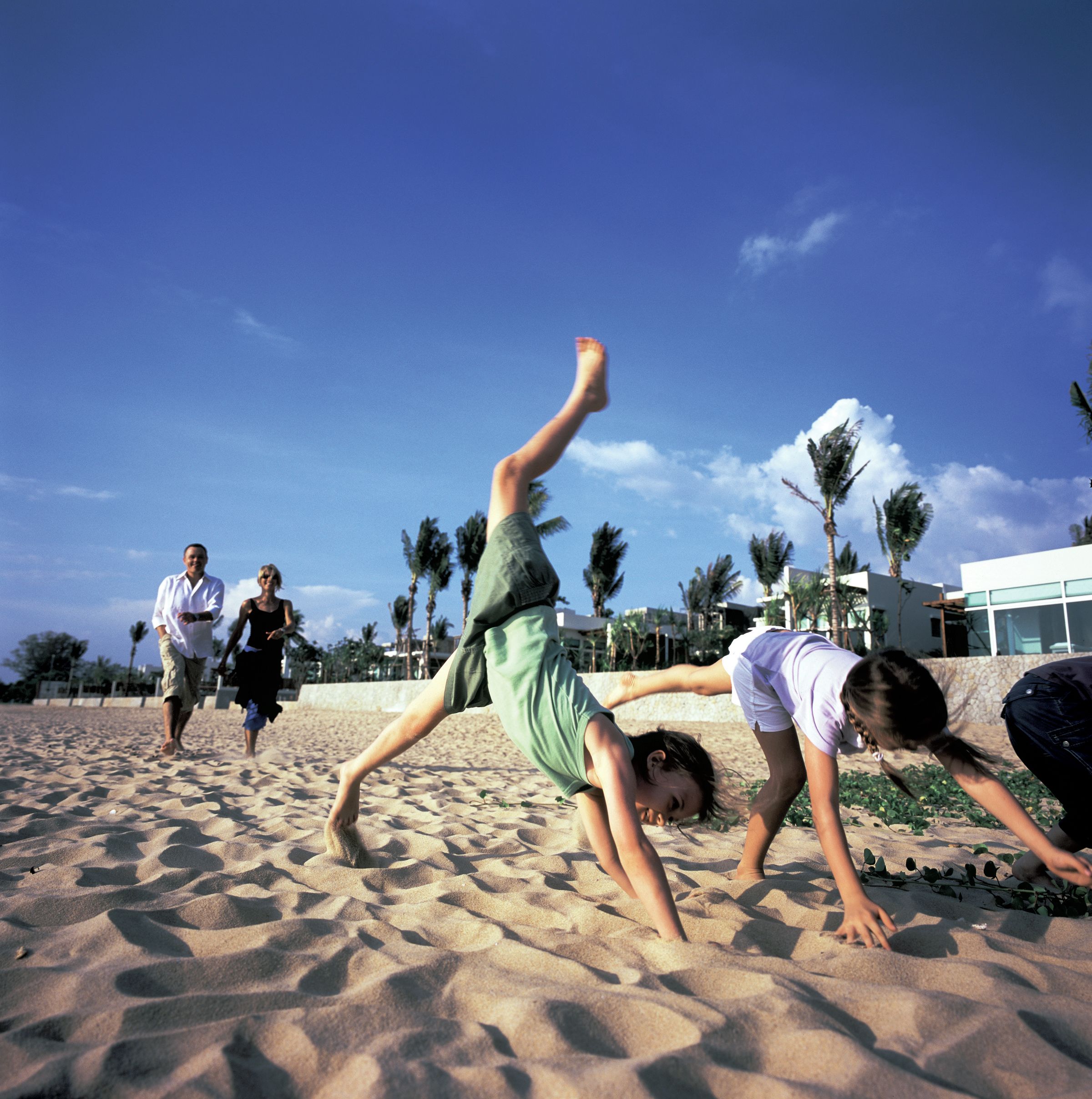 A beach scene with people engaging in physical activities.